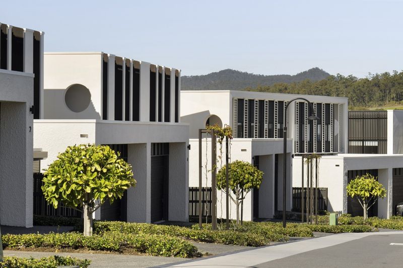 Seasons by Azure in Brookwater, rendered townhouses with round windows and vertical battens, hills behind