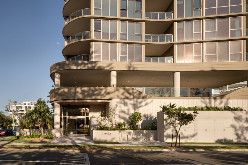 Base of Marella by Mosaic in Broadbeach, curved balconies above a rendered podium, columns and the Marella entry wall