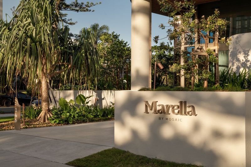 Rendered entry wall with the Marella by Mosaic sign in Broadbeach, framed by tropical planting