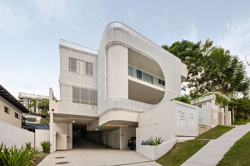 Ravine in Indooroopilly, a white apartment building with a curved rendered balcony form and metal screens